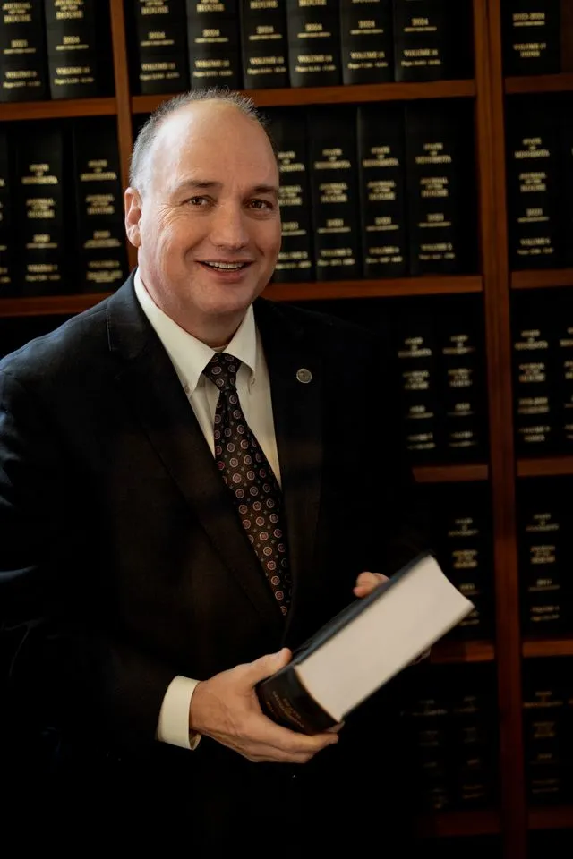 John Huot holding a book in a legislative library.