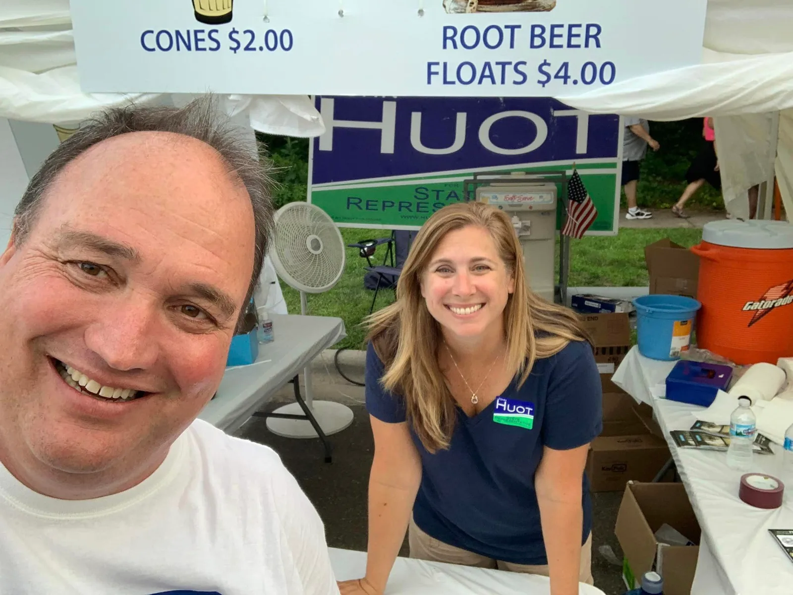 John Huot and a campaign volunteer smiling together at a community booth